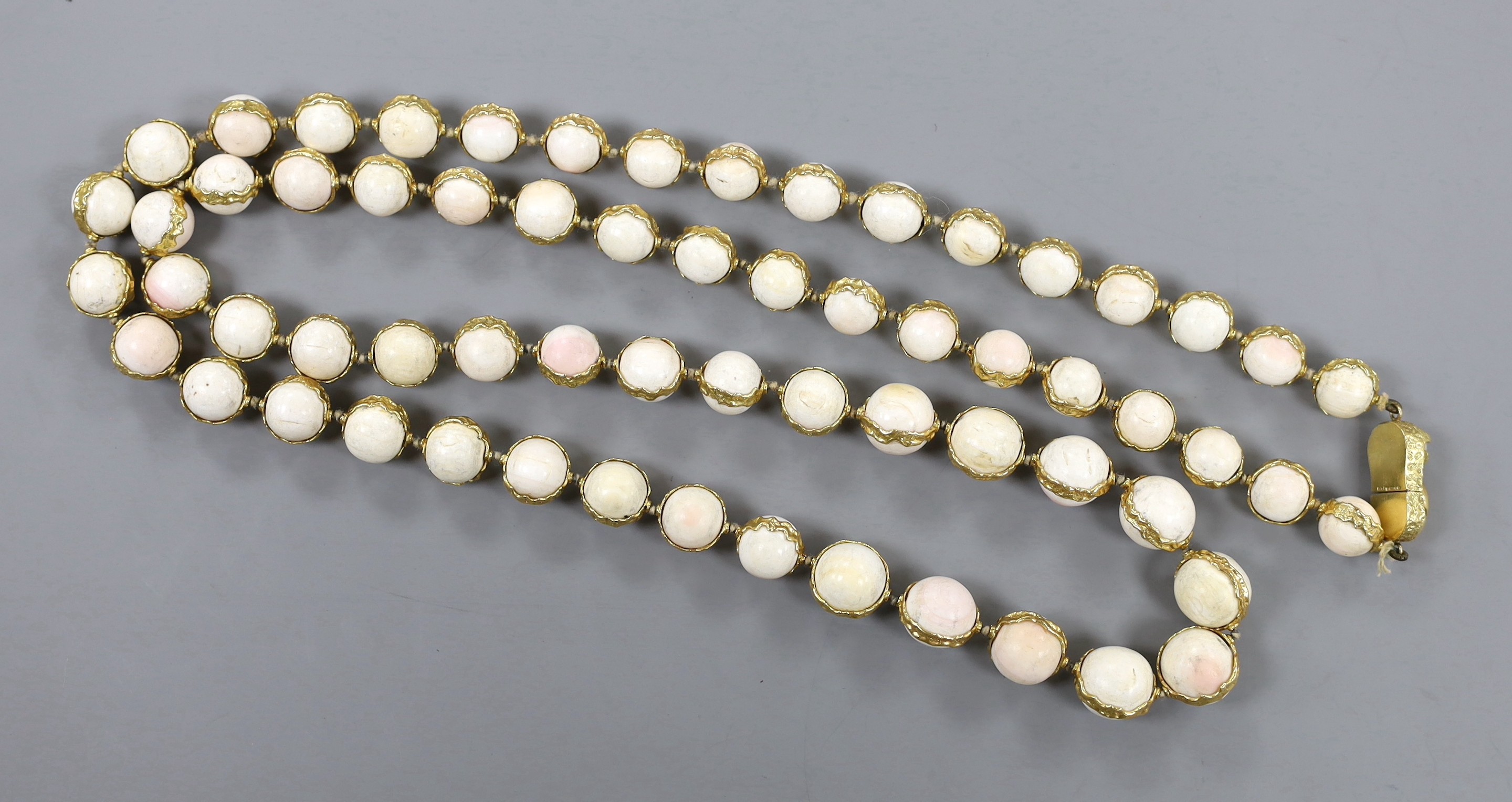 A modern 18ct gold and graduated white coral bead set single strand necklace, with 18ct gold clasp, 99cm, gross weight 212 grams.